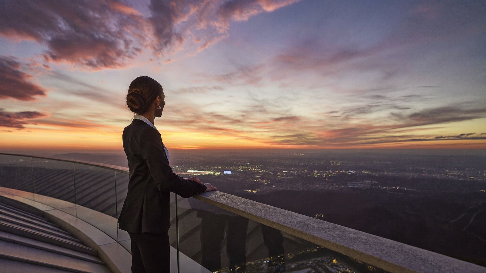 Una profesional mira el horizonte al amanecer sobre el valle de Medellín