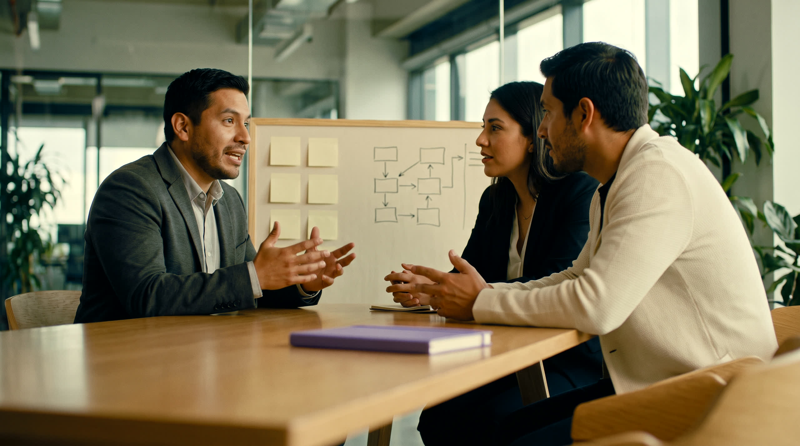 Equipo conversando frente a un tablero de estrategia en una sala cálida