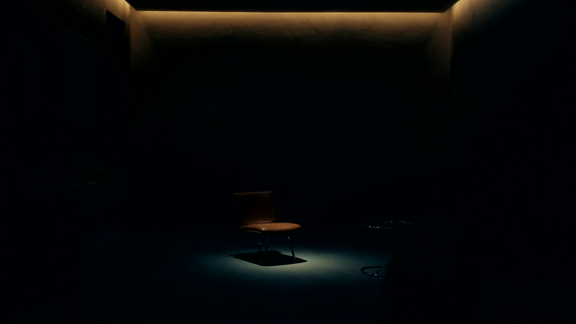 Sala de espera de un consultorio moderno con una silla vacía iluminada en penumbra azulada